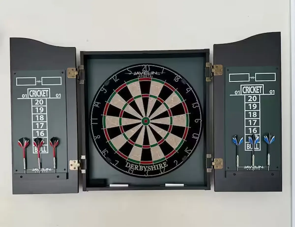 A dartboard mounted on the wall next to a scoreboard, with darts ready for play. The setting is bright and inviting, perfect for friendly competition and group activities.