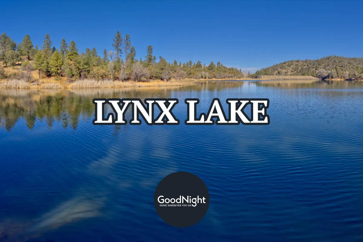A scenic view of Lynx Lake, with glassy reflections of surrounding evergreens and tranquil waters. The peaceful atmosphere is paired with hints of outdoor activities like boating, fishing, and hiking trails visible along the shoreline.
